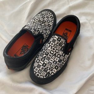 Black, white, and orange slip on Vans. Size 6 mens.